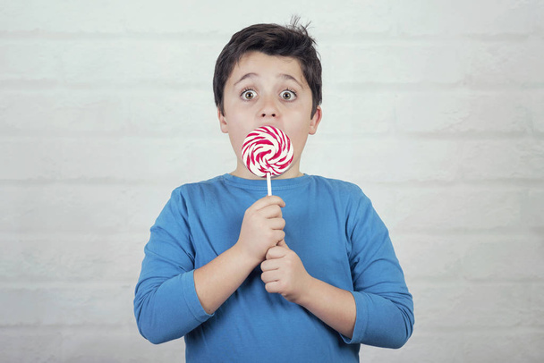 surprised child with lollipop on brick backgroun - Foto, immagini