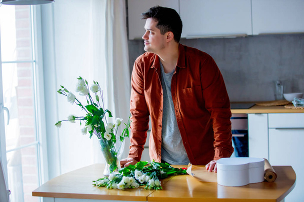 Young man florist working in kitchen at home. Own business concept - Photo, Image