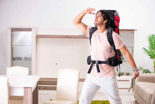 Joven turista masculino preparándose para el viaje en casa
 - Foto, Imagen