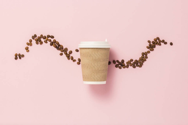 Taza de papel desechable con tapa de plástico para café caliente o té sobre fondo rosa con granos de café. Piso tendido, vista superior
 - Foto, Imagen