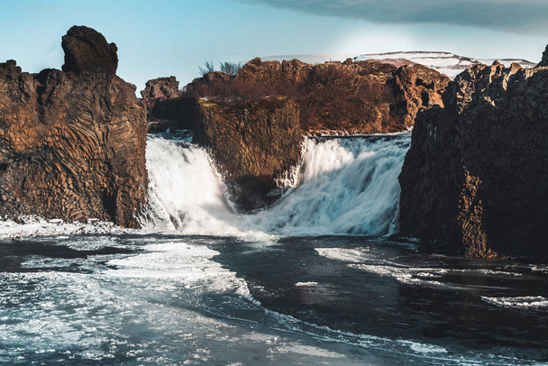 Famous Hjalparfoss double waterfall in southern Iceland with sky and clouds. treking in Iceland. Travel and landscape photography concept - 写真・画像