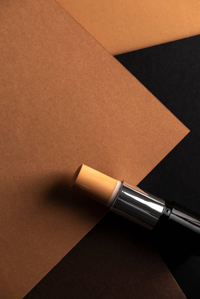 concealer stick, on geometric backgrounds, in shades of brown. Product and makeup concept from above - Φωτογραφία, εικόνα