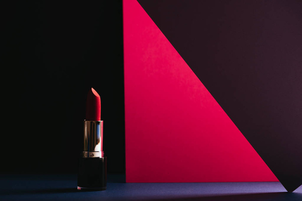 Élégantes photos de maquillage, rouge à lèvres rose sur fond géométrique coloré. Produit et maquillage concept contemporain. vue de face
 - Photo, image