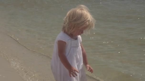 Klein meisje in zonnebril op de kust. - Video