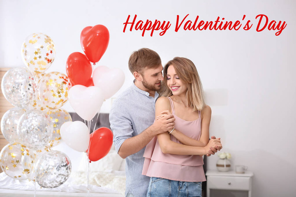 Young couple with air balloons in bedroom and text Happy Valentine's Day - Zdjęcie, obraz