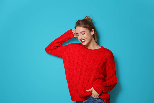 Beautiful young woman in warm sweater on color background - Fotoğraf, Görsel