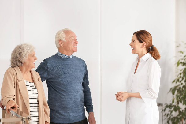 Elderly spouses with female caregiver in room - Foto, Bild