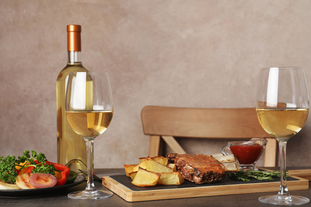 Fried ribs served with garnish, sauce and wine on table, space for text. Delicious meat - Φωτογραφία, εικόνα