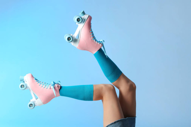 Woman with vintage roller skates on color background, closeup - 写真・画像