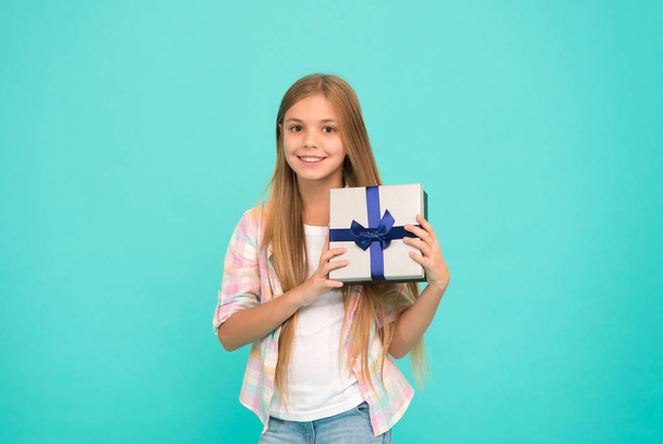 Making gift with soul. Little shopaholic with present wrapped in box. Small child holding gift box tied with ribbon bow. Small girl after shopping for gift. Cute shopper enjoy doing a little shopping - Foto, imagen