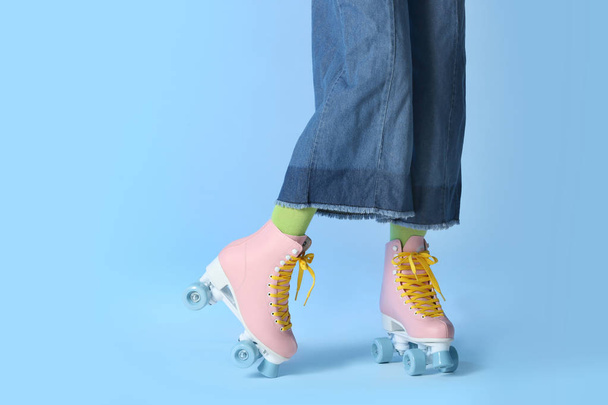 Woman with vintage roller skates on color background, closeup. Space for text - Foto, Imagem