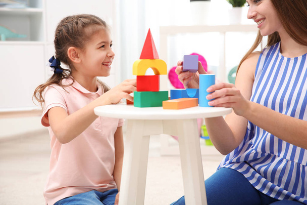 Woman and her child playing with colorful blocks at home - Foto, Imagen