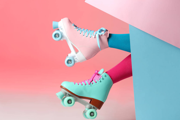 Woman with vintage roller skates on color background, closeup - Photo, Image