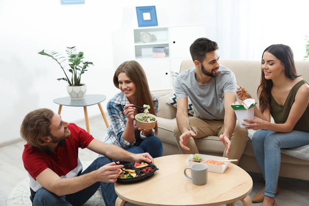 Jovens almoçando juntos na sala de estar. Entrega de alimentos
 - Foto, Imagem