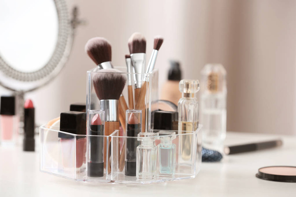 Makeup accessories and cosmetic products on table against blurred background - Valokuva, kuva