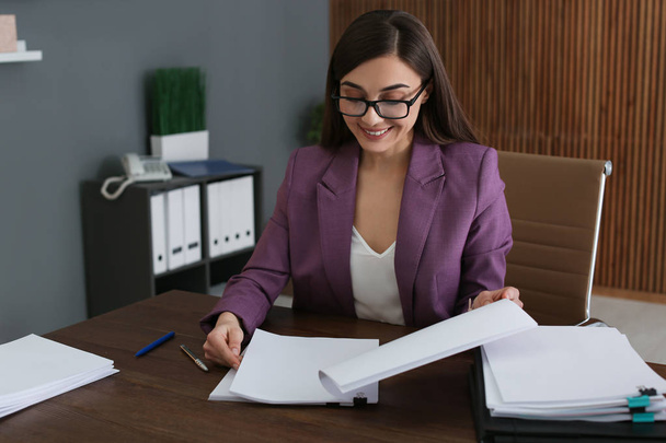 Beautiful businesswoman working with documents at table in office - 写真・画像