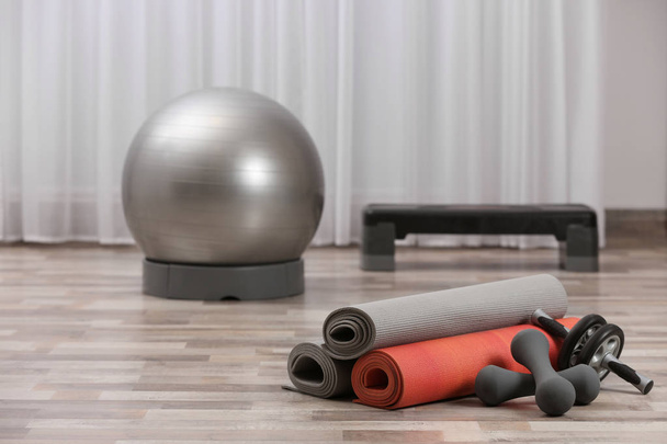 Set of fitness equipment on floor indoors. Space for text - Фото, зображення