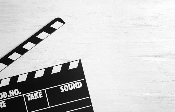 Clapperboard on wooden background, top view with space for text. Cinema production - Fotoğraf, Görsel