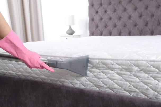 Woman disinfecting mattress with vacuum cleaner, closeup. Space for text - Φωτογραφία, εικόνα