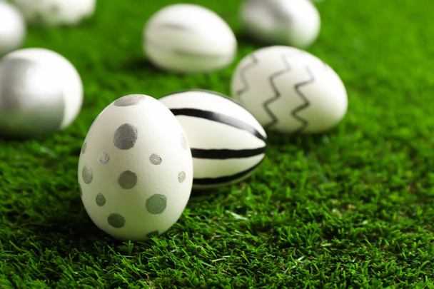 Traditional painted Easter eggs on green lawn, closeup - Foto, Imagem