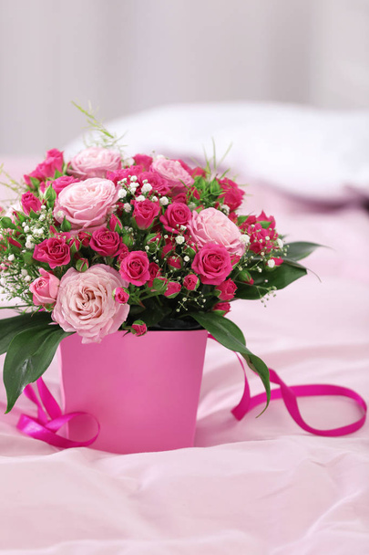 Beautiful bouquet of flowers in paper gift box on bed - Foto, imagen