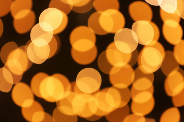 Beautiful golden lights on dark background. Bokeh effect - Фото, зображення