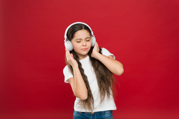 Enjoying her favorite music. Small girl wearing stereo headphones. Little girl listening to music. Cute music fan with wireless headset. Little child using technology for leisure or education - Photo, image
