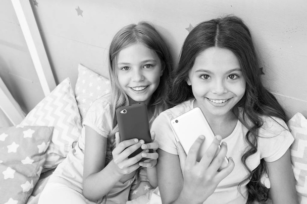 Explore social network. Kids taking selfie. Smartphone application concept. Online entertainment. Girlish leisure pajama party. Girls smartphone little bloggers. Smartphone for entertainment - Фото, зображення