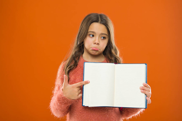 Sad news. Girl hold book orange background. Child show open pages of book or notepad. Book store concept. Free books available to read. Childhood literature. Development and education. Bad mark - Foto, Imagem