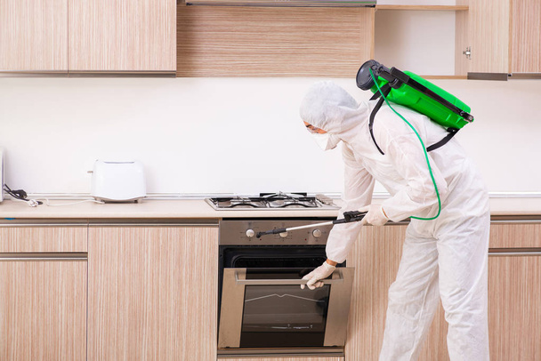 Contratante profissional fazendo controle de pragas na cozinha
 - Foto, Imagem