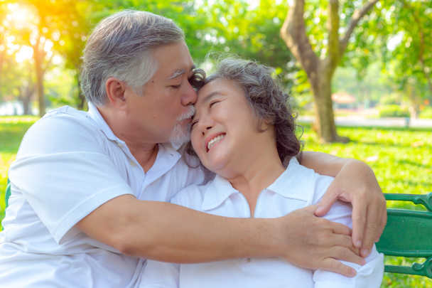 Portrait romantic older couple. Attractive handsome older husband embracing and kissing his older wife with love. Grandfather and grandmother loves each other for long time. They are romantic couple - Photo, Image