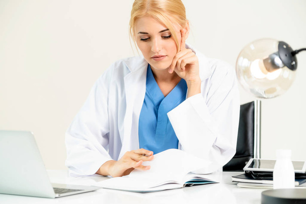 Nő orvos a kórházi vagy az egészségügyi Intézet orvosi jelentés irodai asztal dolgozik. - Fotó, kép