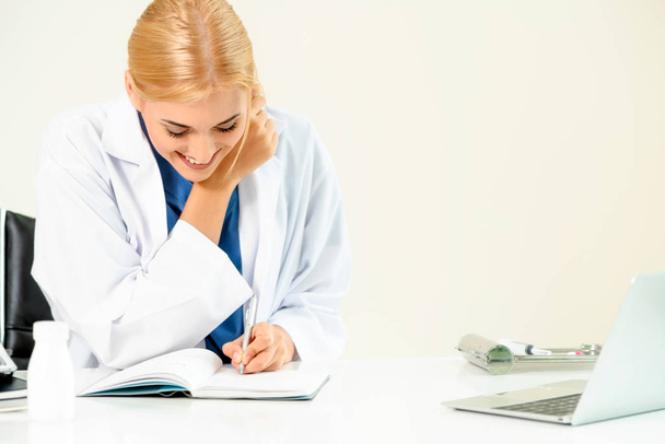 Woman doctor in hospital or healthcare institute working on medical report at office table. - 写真・画像