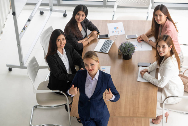 Geschäftsfrau im Gruppengespräch mit anderen Kolleginnen in einem modernen Büro mit Laptop und Dokumenten auf dem Tisch. Menschen Corporate Business Working Team Konzept. - Foto, Bild