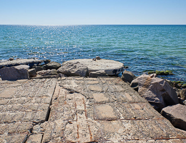 view from the stone pier to the sea and clear blue sky, shooting from below, village Iron Port, Ukraine - Foto, Bild