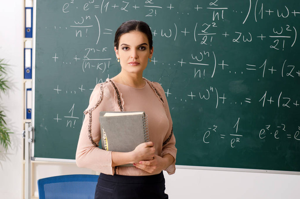 Female teacher standing in front of chalkboard - Valokuva, kuva
