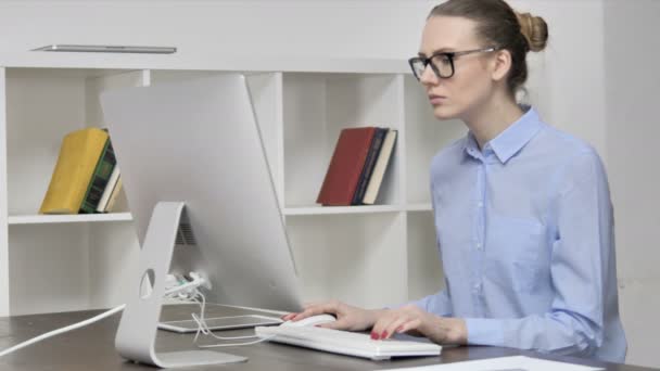 Joven chica casual trabajando en la computadora en la oficina
 - Metraje, vídeo