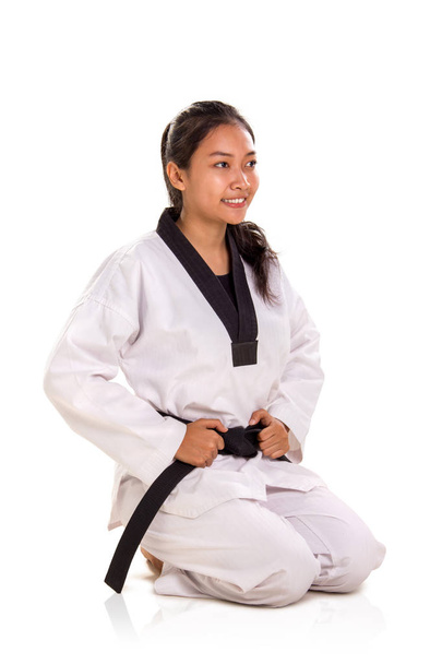 Hermosa mujer asiática sonriente luchadora de arte marcial arrodillada pose, retrato de cuerpo entero en el fondo del estudio
 - Foto, Imagen