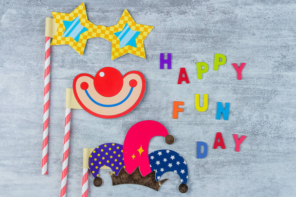 April fools day colorful wooden letters alphabet and Photo booth colorful props for party on gray background. Holiday greeting postcard. Flat lay, top view - Photo, Image
