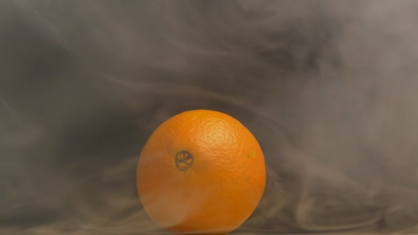 Juicy and ripe orange fruit from which evaporation and freshness are on a black background, close-up, copy space, slow motion - Video, Çekim