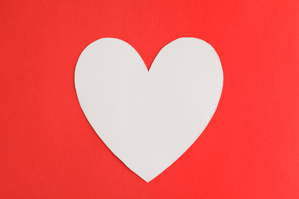 Бумага в форме сердца на фоне красной бумаги
 - Фото, изображение