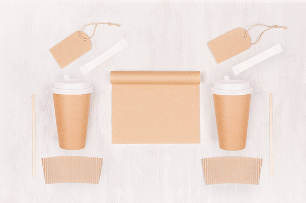 Coffee branding identity mockup - set of two brown paper cups with blank notebook, label, sugar on white wood board, top view. - Fotó, kép