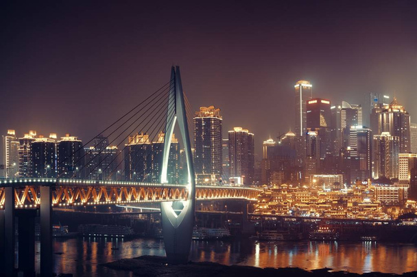 Puente Qiansimen con el complejo comercial Hongyadong y la arquitectura urbana de la ciudad por la noche en Chongqing, China. - Foto, imagen