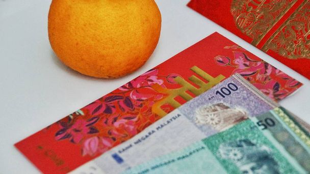 Pacchetto cinese di denaro rosso per il nuovo anno con note malesi RM100, RM50, RM10, RM1 isolate su sfondo bianco.
. - Foto, immagini