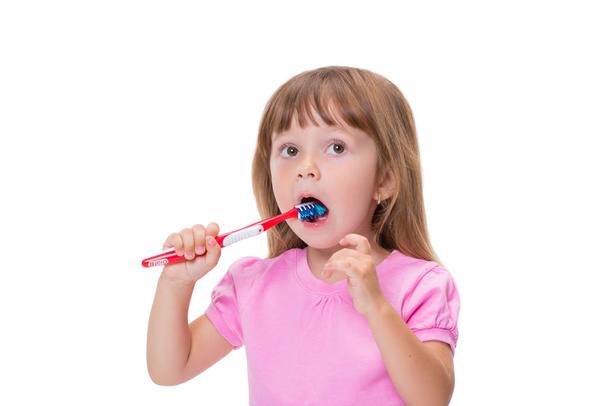 Közeli kép: portré aranyos kis lány 3 éves, rózsaszín póló fogmosás a fogát elszigetelt fehér background. - Fotó, kép