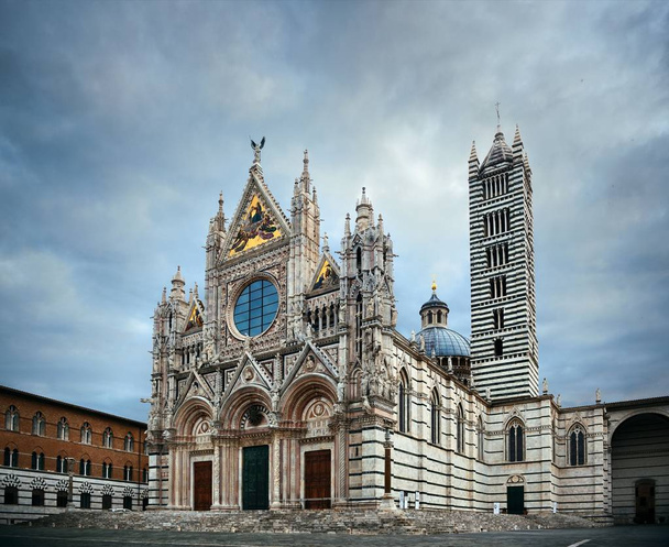Zbliżenie katedry w Sienie jako słynny zabytek średniowiecznego miasta w pochmurny dzień we Włoszech. - Zdjęcie, obraz