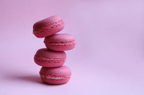 Four pink macaroons on a light pink background, minimal food concept - Fotografie, Obrázek