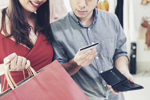 Пара перевіряє кредитну картку після покупки в торговому центрі
 - Фото, зображення