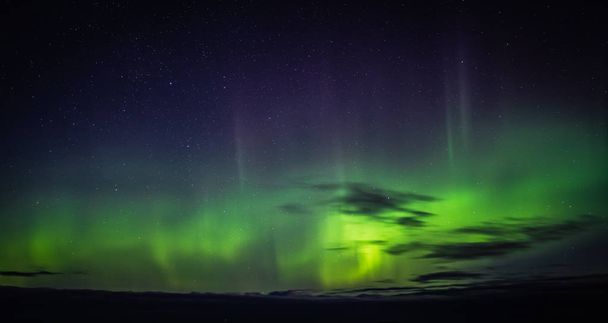 Северное сияние Aurora Borealis видно с Атлантического океана Road - Atlanterhavsveien в зимнюю ночь. Зима в Норвегии. Красивое звездное небо и зеленые огни
. - Фото, изображение