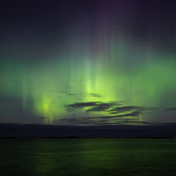 Aurora Boreal vista desde Atlantic Ocean Road Atlanterhavsveien en la noche de invierno. Invierno noruego. Bonito cielo estrellado y luces verdes
. - Foto, Imagen